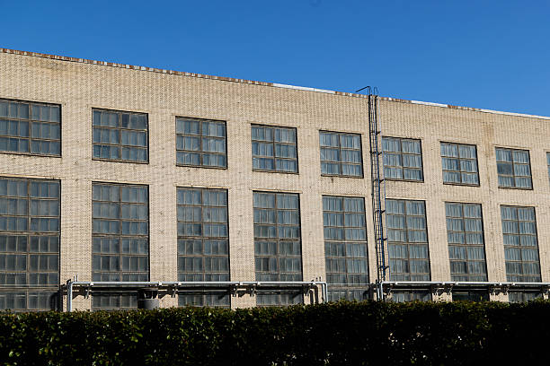 istock An Industrial Building Facade Showcasing Expansive Large Windows Beneath a Clear, Bright Blue Sky 2238204089