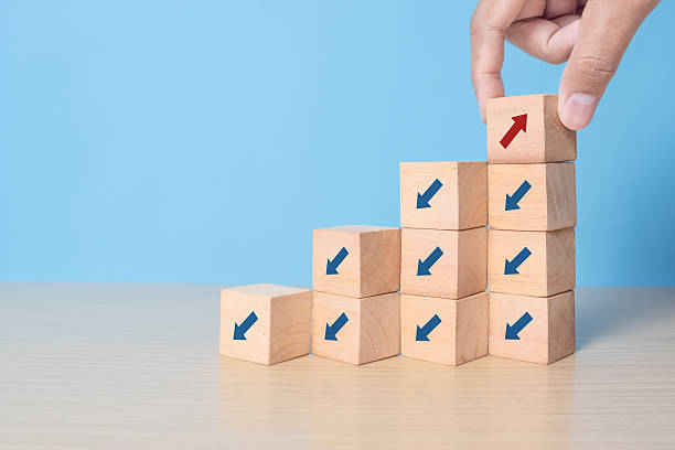 istock wooden block cubes with rising business graph among decline graph 2238208103