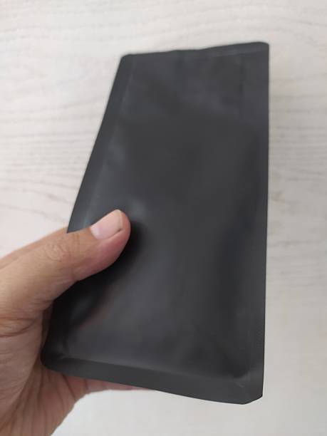 istock Hand holding black matte stand-up punch mockup 2238212778