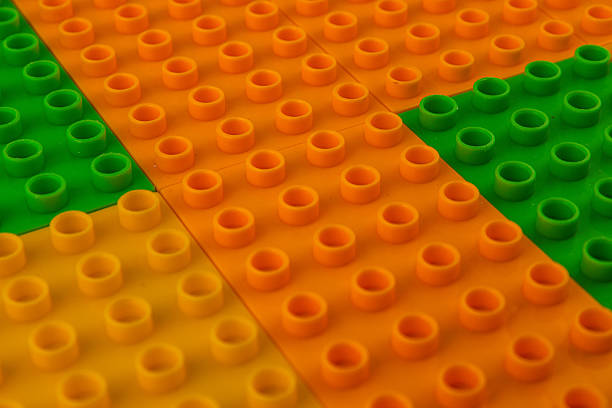 Brightly colored building blocks are arranged on a flat surface, showcasing vibrant orange, green, and yellow pieces in an engaging layout that invites creativity.
