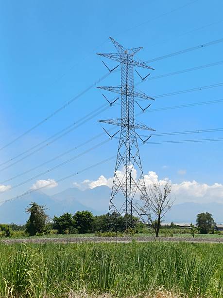 istock Tall Electricity Tower Standing in Green Fields with Mountain View 2238214078