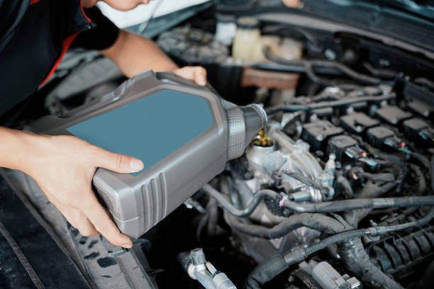 istock Mechanic pouring engine oil into a car engine for maintenance 2238215851