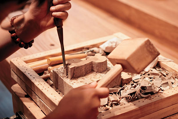 Skilled craftsman using chisel and mallet to carve wood
