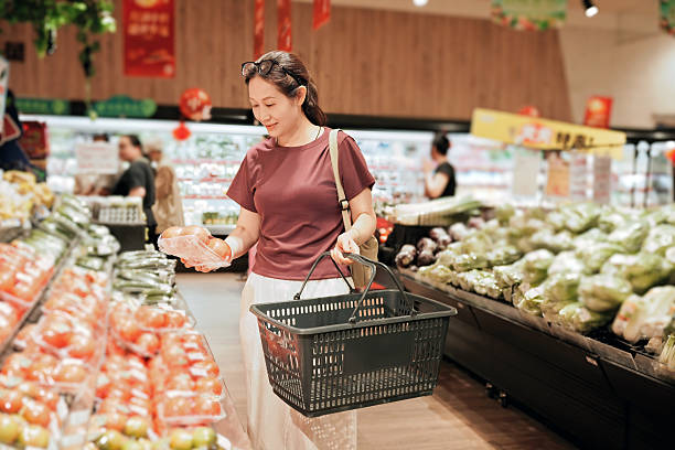 istock Woman selecting fresh tomatoes in a supermarket 2238216996