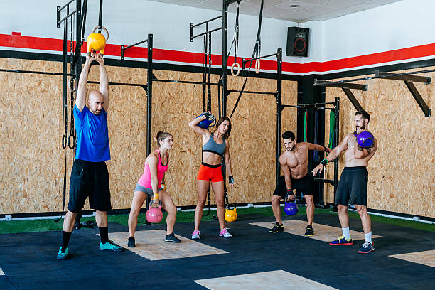 Group of athletes lifting weights at a gym.
