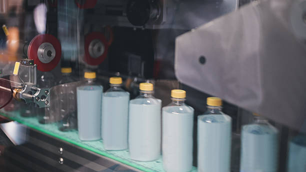 labeling and sealing packaging machine in PET plastic packaging drinking or beverage product packaging line automated labeling of round containers in smart production facility