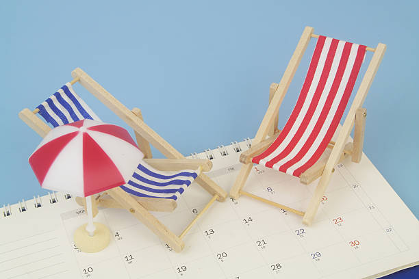 istock Red and blue beach chairs with umbrella on calendar on blue background. 2238224973