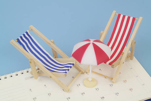 istock Red and blue beach chairs with umbrella on calendar on blue background. 2238224977