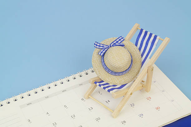 istock Blue beach chair with hat on calendar on blue background. 2238224994