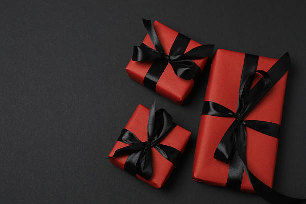 istock red gift boxes with black ribbons on a black background 2238231856