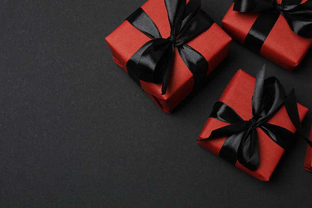 istock red gift boxes with black ribbons on a black background 2238232037
