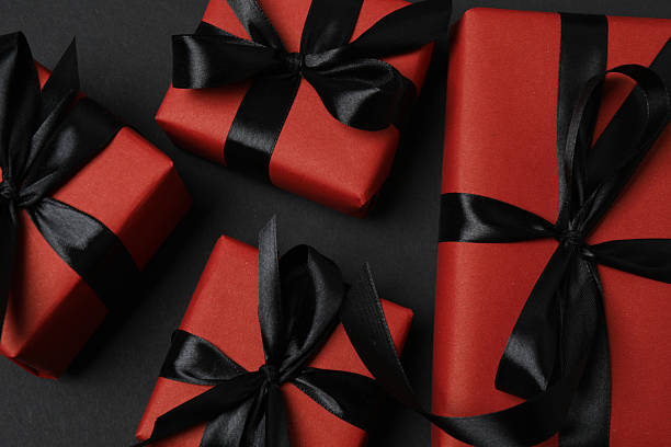 istock red gift boxes with black ribbons on a black background 2238232039