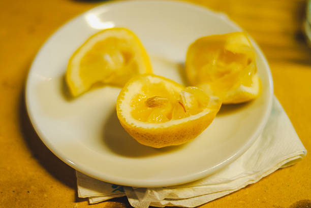 istock Close up of three fresh lemon wedges resting on a white ceramic plate with a folded paper napkin underneath in a rustic Italian setting suggesting a taste of sunny Lombardy 2238233952