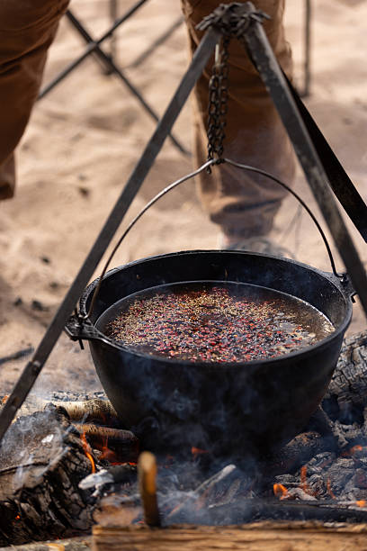 istock Cooking at the campsite, adding a spice mixture to the cauldron 2238234103