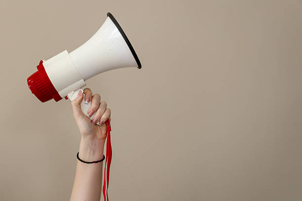 istock Hand holding megaphone against neutral background 2238235784