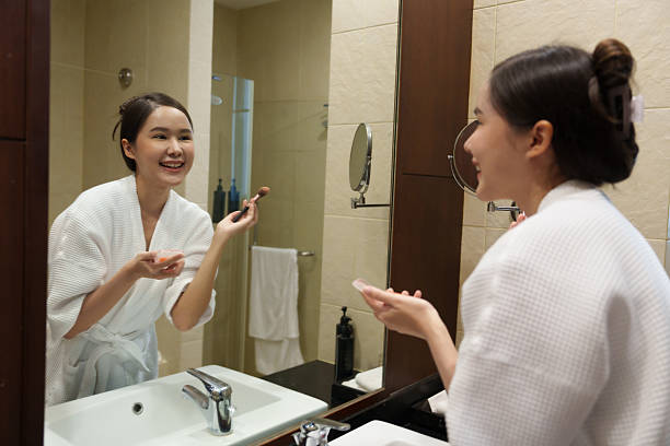 istock A young woman is putting on makeup in her vacation room. 2238237270
