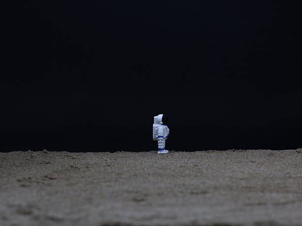 istock The image shows a miniature astronaut standing on a sandy or dusty surface resembling the landscape of the moon or planet. 2238238848