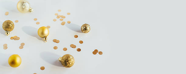 istock Golden Christmas balls and confetti on a white table 2238240378
