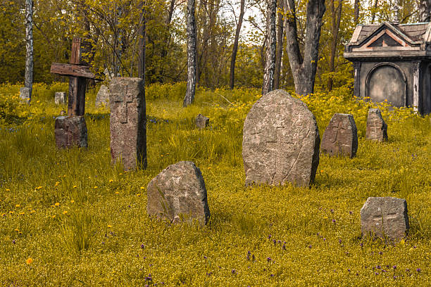 Old stone crosses and crypt at ancient cemetery. Abandoned graveyard