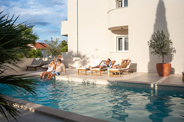 istock Diverse Group of Friends Relaxing by Modern Villa Pool at Sunset 2238248300