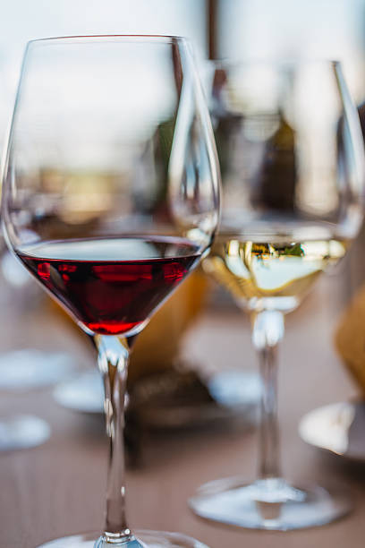 istock 2 elegant wine glasses. Bottles blurred in the background. 2238248815
