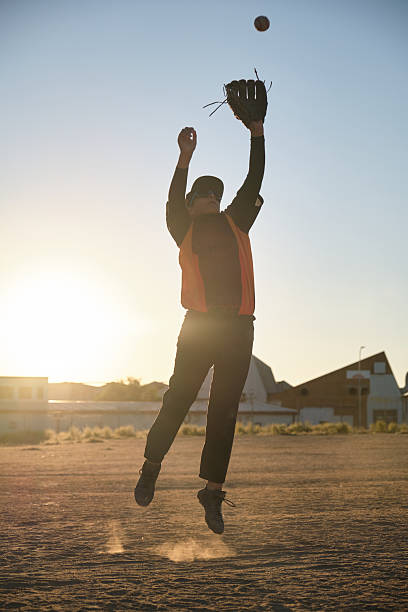 istock Baseball player catching ball in air at sunset 2238254898
