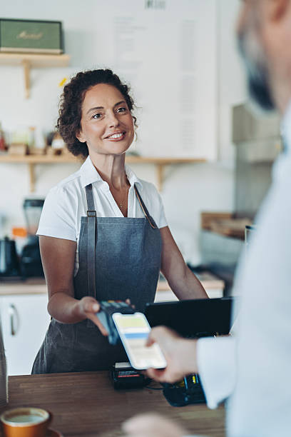 istock Smiling barista accepting a contactless mobile payment 2238255675