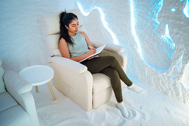 istock Hispanic Young Woman Relaxing in a Tranquil Salt Room While Writing in a Notebook 2238257475