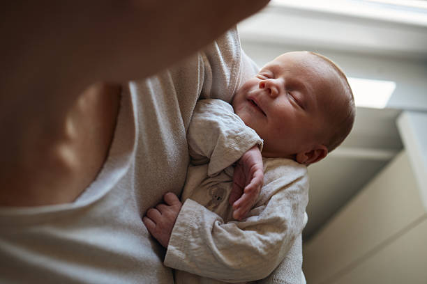 istock Parent holding sleeping newborn baby tenderly 2238257796