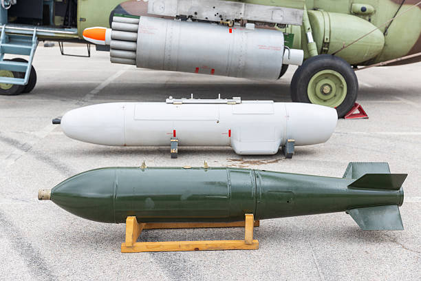 Military aviation weapons on display, including aerial bombs, rocket pods, and guided missiles, presented at an air force exhibition showcasing defense technology