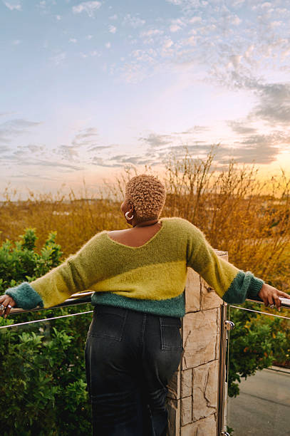 istock Joyful Black Woman Enjoying Serene Sunset Outdoors Wearing Cozy 2238259799
