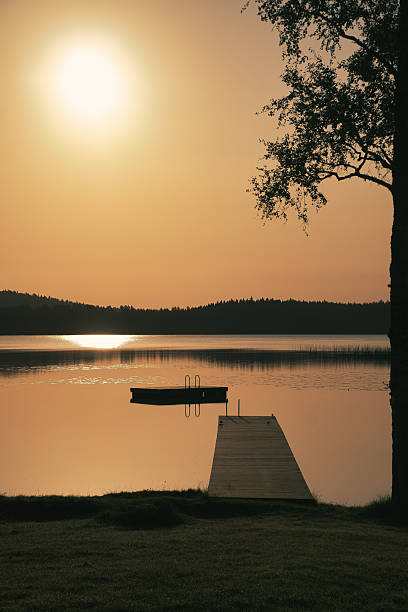 istock Romantic jetty on the lake at sunset with calm water 2238259994