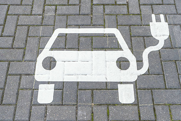 istock White electric car charging icon painted on a cobblestone parking space 2238260132