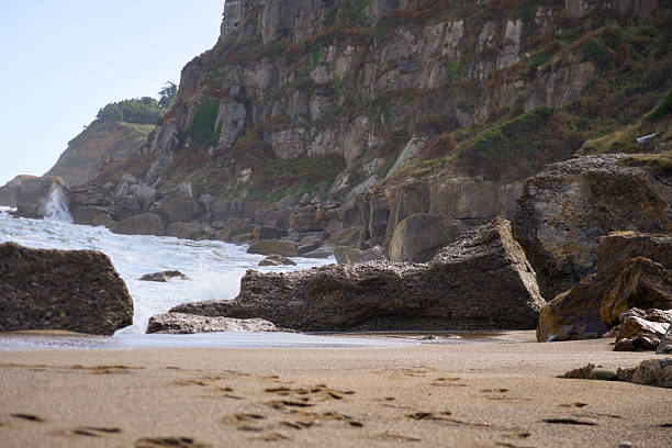 Seashore with rocks sand and ocean waves