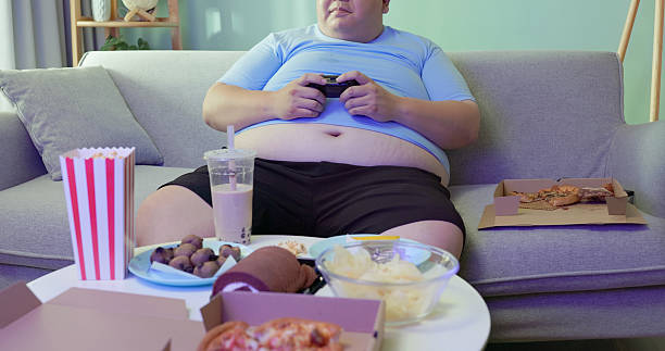 istock obese man eating junk food at home 2238266373