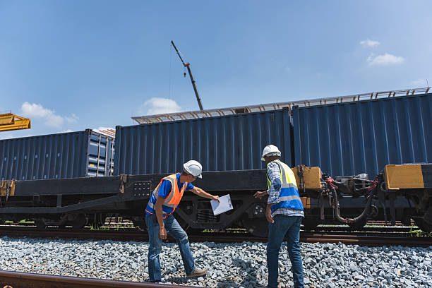 istock Railroad Workers Reviewing Checklist at Intermodal Freight Yard, Logistics Team Inspecting Shipping Containers on Train Flatcar, Engineers Working by Cargo Train, Transport and Supply Chain Management 2238268326