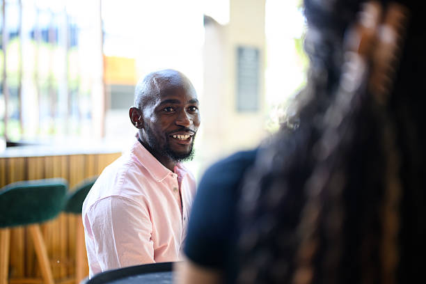 istock Portrait of cheerful man smiling toward a server while dining at a restaurant table with soft background light 2238273560