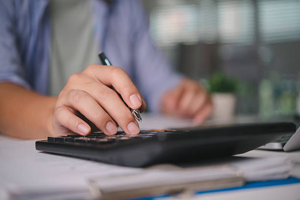 istock Accountant calculating finance data on calculator, working on business documents, audit report, money management, tax season, investment analysis, financial planning with paperwork at the office. 2238273642