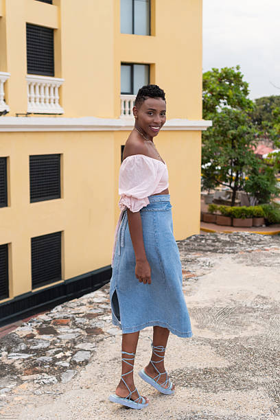 Stylish black woman posing on a city rooftop