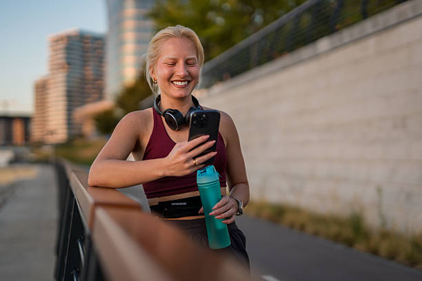 istock Woman smiling, checking phone after outdoor workout 2238276618