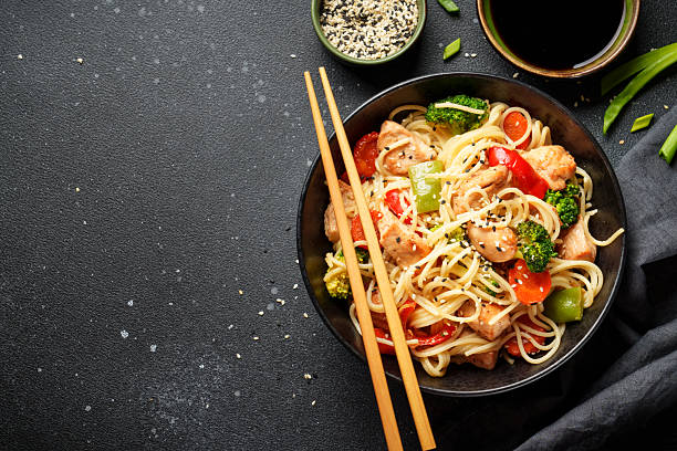 istock Asian noodles with chicken and vegetables at black background. 2238279436