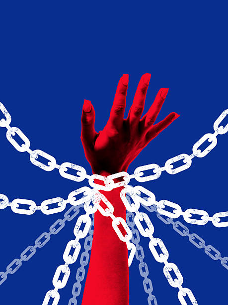 istock Bold collage. Red hand tied by multiple chains reaching out with desperate emotion 2238279586