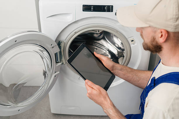 istock Repairing a washing machine at home while using a tablet for service guidance 2238281033
