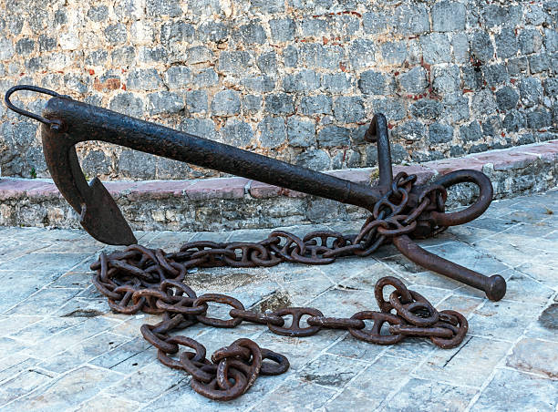 Pile of old rusty chains is laying on the ground, creating an interesting industrial background