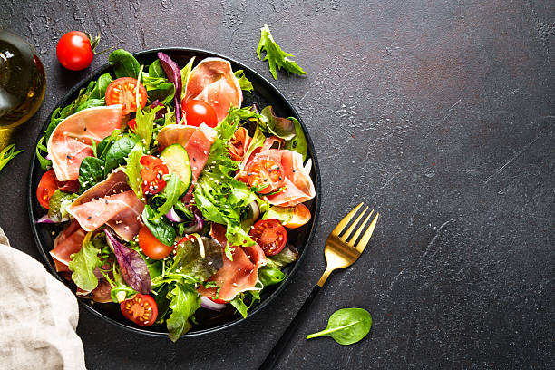 istock Salad in black bowl at dark background. 2238282671