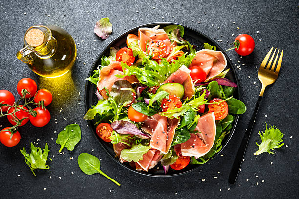 istock Salad in black bowl at dark background. 2238282681