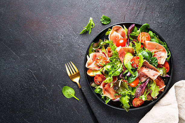 istock Salad in black bowl at dark background. 2238282718