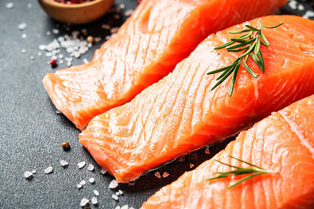 istock Salmon fillet, raw fresh fish at black table. 2238283029