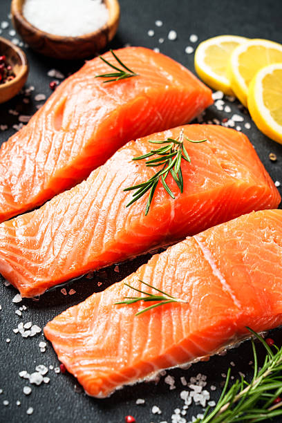 istock Salmon fillet, raw fresh fish at black table. 2238283145
