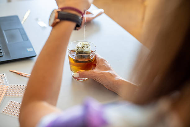 Woman preparing herbal tea at work